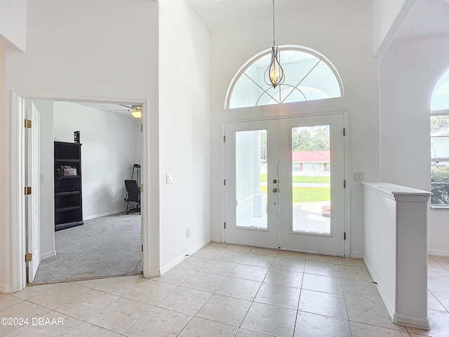 foyer featuring a wealth of natural light, french doors, a towering ceiling, and ceiling fan