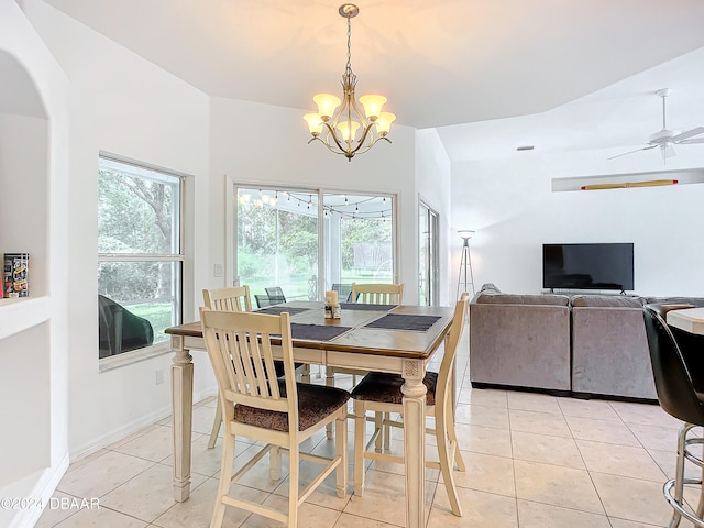 tiled dining room with ceiling fan with notable chandelier