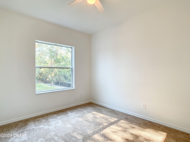 spare room featuring ceiling fan and carpet