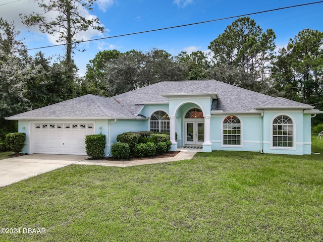 single story home featuring french doors, a front yard, and a garage