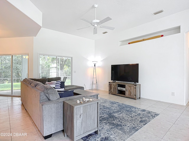 living room featuring light tile patterned floors, a towering ceiling, and ceiling fan