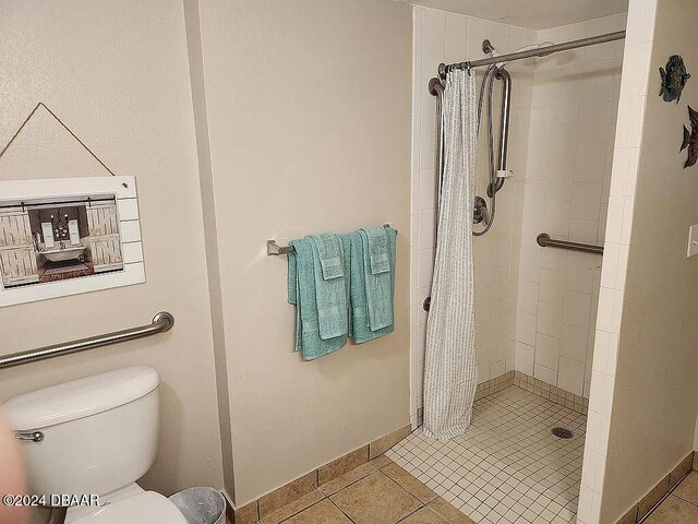 bathroom with walk in shower, toilet, and tile patterned flooring