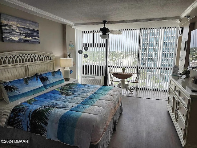 bedroom featuring access to exterior, hardwood / wood-style flooring, ornamental molding, and multiple windows