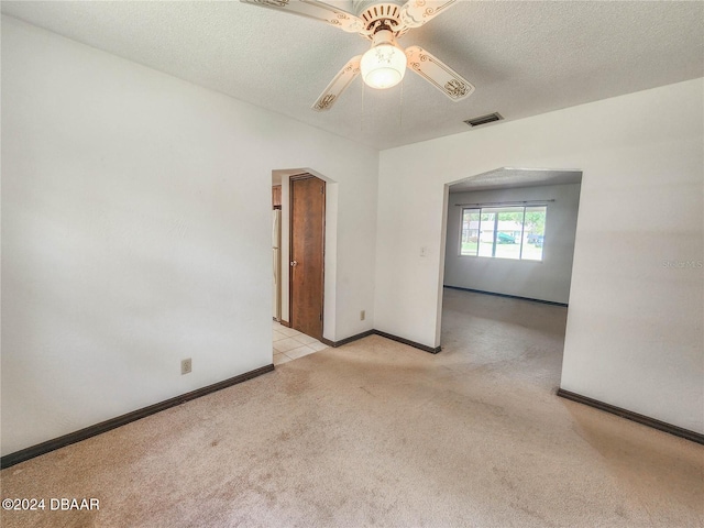 carpeted empty room with a textured ceiling and ceiling fan