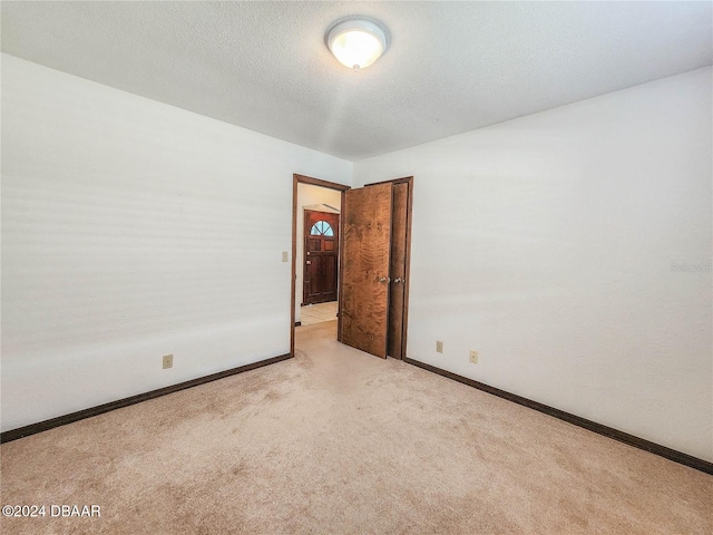 carpeted spare room with a textured ceiling