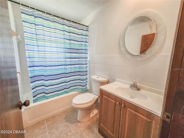 full bathroom featuring toilet, vanity, tile walls, a textured ceiling, and shower / tub combo with curtain