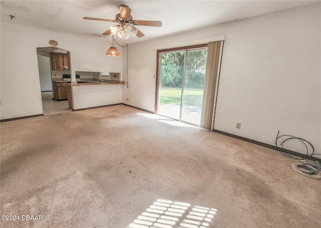1119 Indigo Rd, Ormond Beach, FL 32174 - unfurnished living room featuring light carpet, a ceiling fan, and baseboards