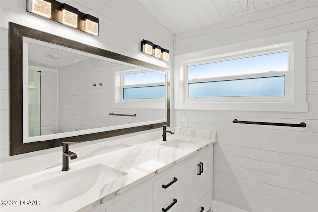 bathroom featuring wood walls, plenty of natural light, and vanity