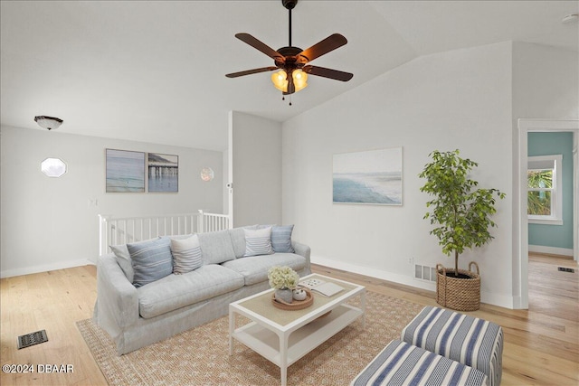 living room featuring lofted ceiling, ceiling fan, and light wood-type flooring