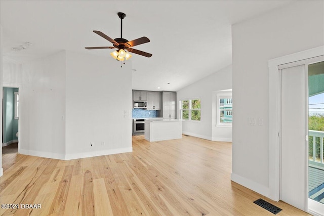 unfurnished living room featuring ceiling fan, light wood-type flooring, and lofted ceiling