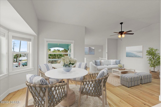 dining room featuring ceiling fan, light hardwood / wood-style floors, and vaulted ceiling