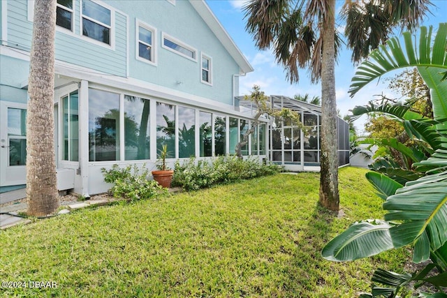 back of property with a lawn and glass enclosure