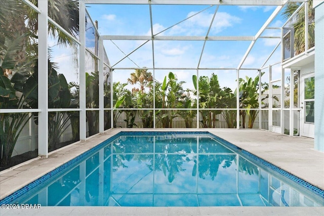 view of swimming pool with glass enclosure and a patio area