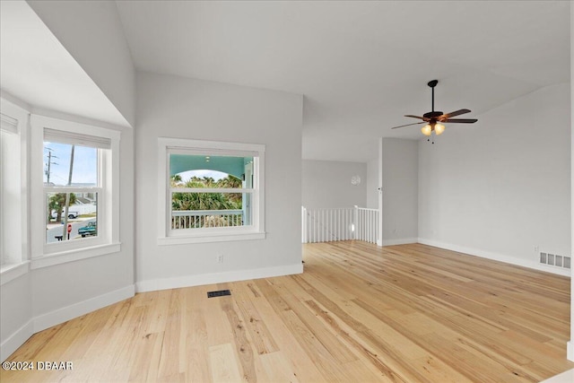 unfurnished living room featuring vaulted ceiling, light hardwood / wood-style flooring, and ceiling fan