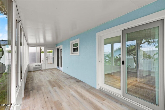 unfurnished sunroom with a wall mounted AC and a wealth of natural light