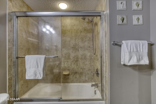 2071 S Atlantic Ave Unit 605, Daytona Beach, FL 32118 - full bathroom featuring enclosed tub / shower combo, toilet, and a textured ceiling