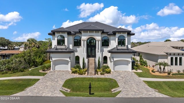 mediterranean / spanish house with a front lawn, a garage, and french doors