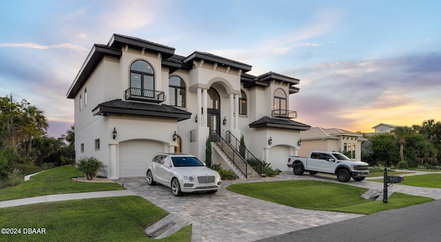 mediterranean / spanish house with a garage, a balcony, and a yard