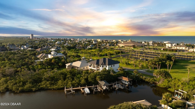 aerial view at dusk featuring a water view