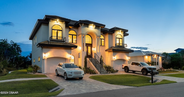 mediterranean / spanish home featuring a garage and a lawn