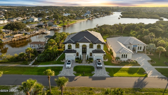 aerial view at dusk featuring a water view