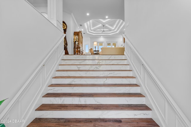 stairway featuring hardwood / wood-style floors and crown molding