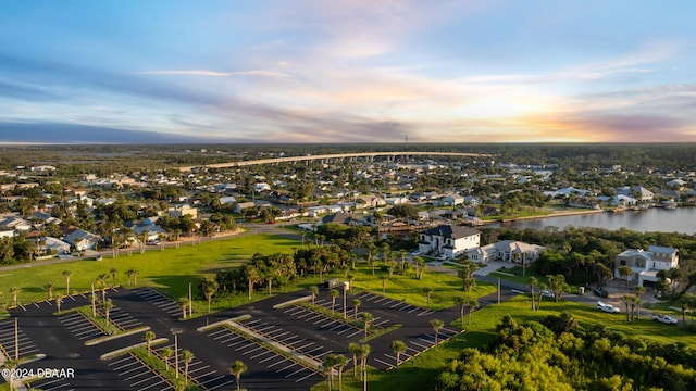 aerial view at dusk featuring a water view