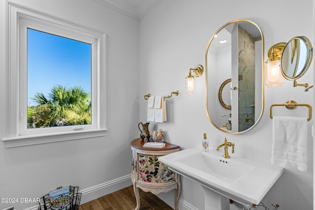 bathroom featuring ornamental molding and hardwood / wood-style flooring