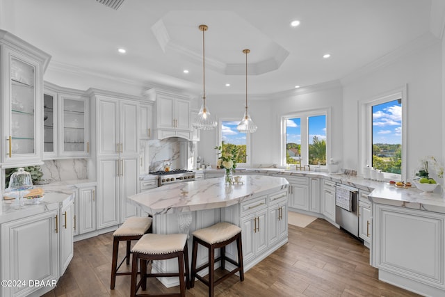 kitchen with backsplash, white cabinets, a breakfast bar, and a center island