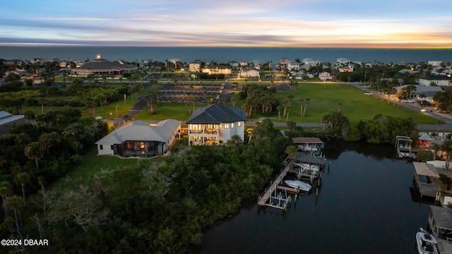 aerial view at dusk featuring a water view