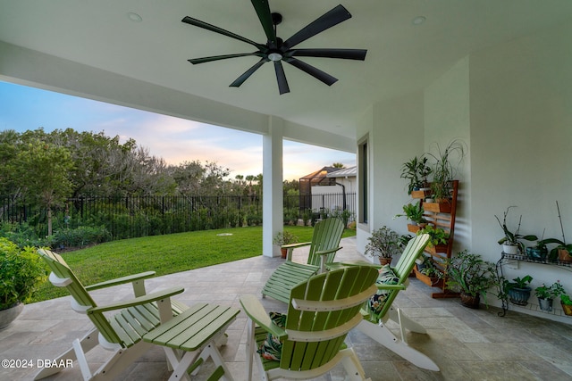 patio terrace at dusk with a lawn and ceiling fan