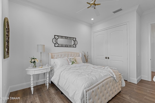 bedroom with crown molding, ceiling fan, dark hardwood / wood-style floors, and a closet