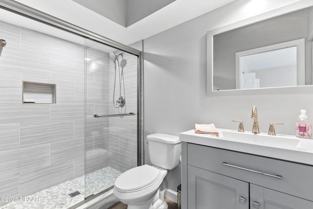 bathroom featuring a stall shower, vanity, and toilet