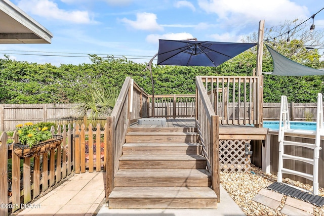 wooden deck featuring a fenced backyard, stairway, and a fenced in pool