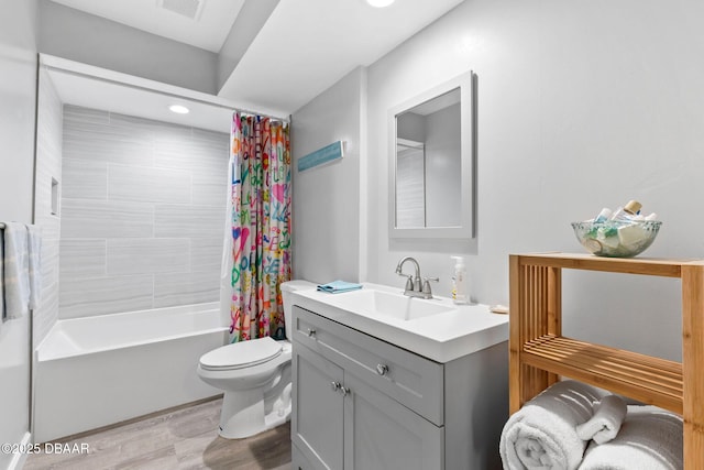 bathroom with shower / tub combo with curtain, visible vents, toilet, vanity, and wood finished floors