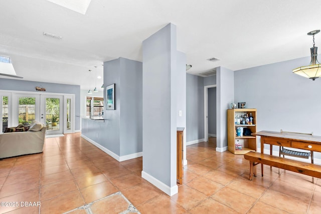 hallway featuring french doors, a skylight, visible vents, and baseboards