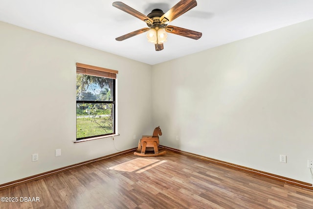 spare room with a ceiling fan, baseboards, and wood finished floors