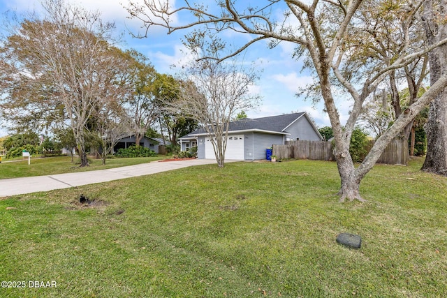 view of side of property featuring driveway, a yard, an attached garage, and fence