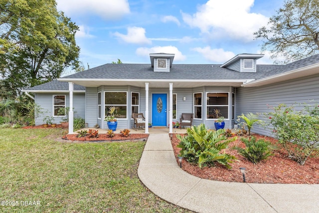 view of front of home with a shingled roof, a front yard, and covered porch