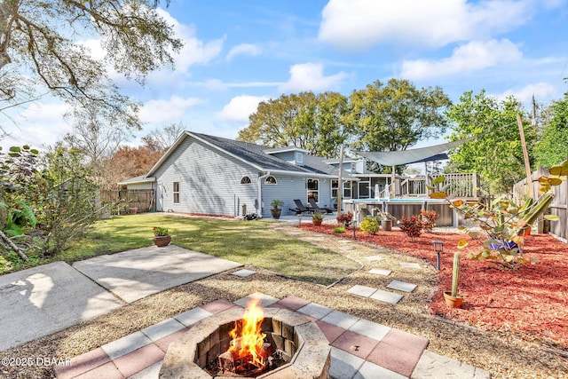 rear view of property featuring a fire pit, a yard, a patio area, and a fenced backyard