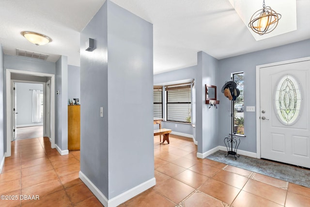 entrance foyer featuring light tile patterned flooring, visible vents, and baseboards