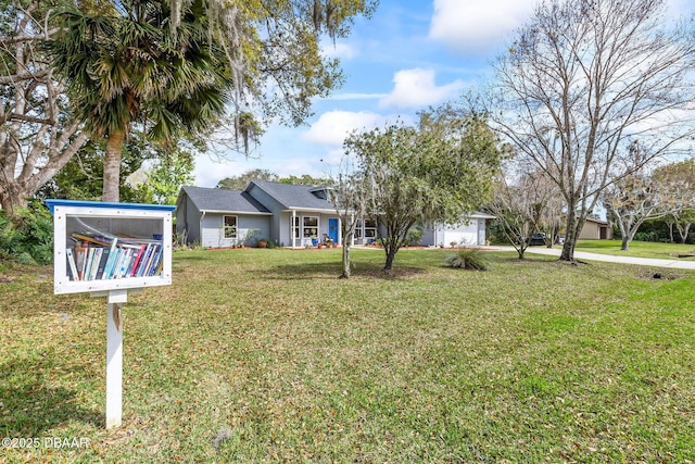 view of front of property featuring a garage, a front yard, and driveway