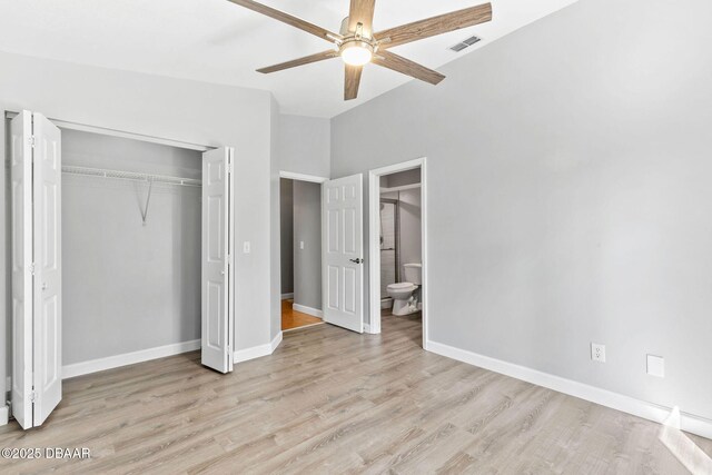 unfurnished bedroom featuring ensuite bathroom, light wood-style flooring, visible vents, baseboards, and a closet