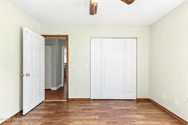 unfurnished bedroom with a ceiling fan, a closet, baseboards, and wood finished floors