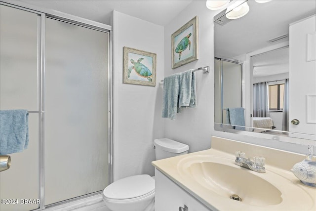 bathroom with toilet, vanity, and an enclosed shower