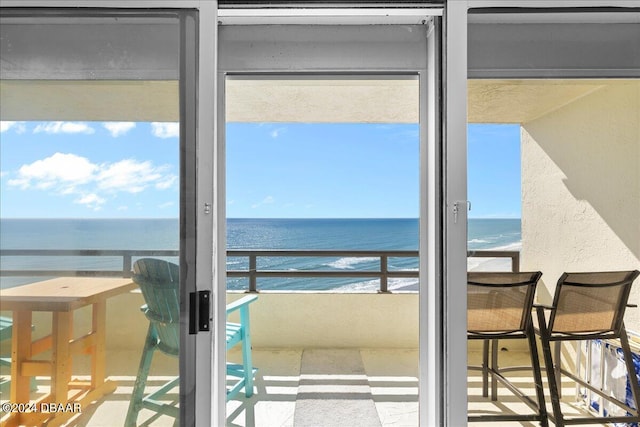 balcony featuring a view of the beach and a water view