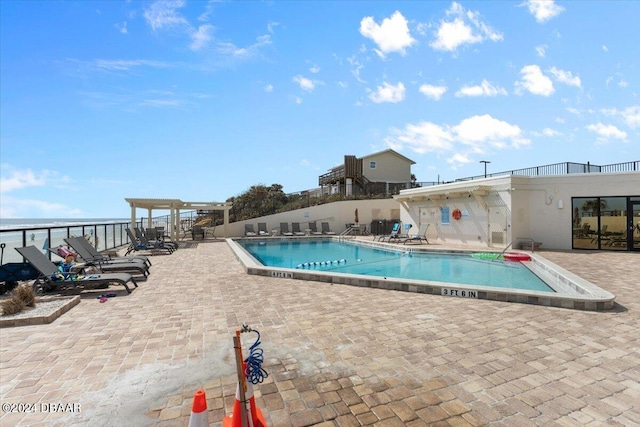 view of swimming pool featuring a patio and a water view