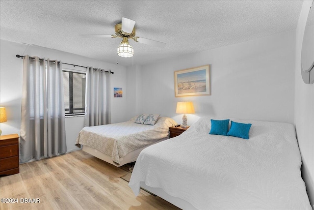 bedroom featuring a textured ceiling, light hardwood / wood-style flooring, and ceiling fan