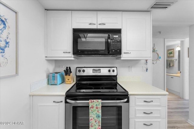 kitchen with light hardwood / wood-style floors, stainless steel electric range, and white cabinetry