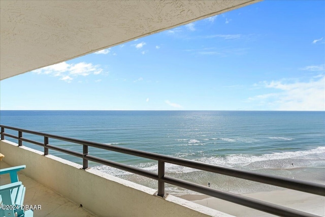 balcony featuring a water view and a beach view